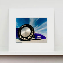 Load image into Gallery viewer, Mounted photograph by Richard Heeps. This photograph has the tyre and the very front tip of a drag car. The car's name is written on the front end "God Speed". Behind the car are white vertical clouds shooting through a blue sky.