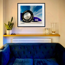 Load image into Gallery viewer, In Situ photograph by Richard Heeps. This photograph has the tyre and the very front tip of a drag car. The car's name is written on the front end "God Speed". Behind the car are white vertical clouds shooting through a blue sky.