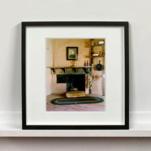 Load image into Gallery viewer, Black framed photograph by Richard Heeps. Film set of 'The Outlaw Josey Wales' featuring a wooden fireplace and a black and white photo over the mantlepiece.