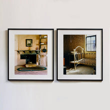 Load image into Gallery viewer, Black framed photographs by Richard Heeps. The first is from the Film set of 'The Outlaw Josey Wales' featuring a wooden fireplace and a black and white photo over the mantlepiece. The second photograph is of a bedroom in an abandoned town featuring a bed frame, stand and wash basin.