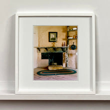Load image into Gallery viewer, White framed photograph by Richard Heeps. Film set of 'The Outlaw Josey Wales' featuring a wooden fireplace and a black and white photo over the mantlepiece.