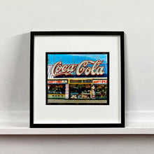 Load image into Gallery viewer, Black framed photograph by Richard Heeps. Harry's Corner was taken on the wildwood boardwalk, featuring neon typography and the iconic Coca-Cola sign against a bright blue sky. 