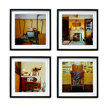 Load image into Gallery viewer, Four black framed photographs by Richard Heeps. From Richard's series Ordinary Places, the four photos capture vintage indoor scenes. The first one is a television, with 4 walking sticks and a bed pan hanging from the picture rail behind, the second one is a sitting room with a fireplace and candlesticks, the third is a vintage radio with a telephone on top of it, the fourth photo is of a brown leather barbers chair with the colourful cutting gown hanging over a bar on the chair.