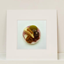 Load image into Gallery viewer, Mounted photograph by Richard Heeps. A vintage pink soap dish sits on a white surface. Looking down onto the soap dish which contains two plugs, green soap, nail brush, cork and a sponge/wire wool combo.