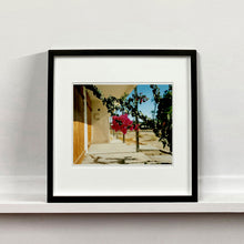 Load image into Gallery viewer, Black framed photograph by Richard Heeps. A flowering bougainvillea hangs outside a motel entrance.