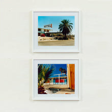 Load image into Gallery viewer, Two white framed photographs by Richard Heeps. The top photograph is of a derelict motel office sitting on a dusty American road. A large palm tree sits at the front of the office's walkway. The bottom photograph is the outside of a derelict motel, the building has strong colours on it and sits against a beautiful blue sky. There is a palm tree behind the motel and sitting to the left of the scene.