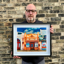 Load image into Gallery viewer, Richard Heeps holding La Belle Femme in the Sun framed in black