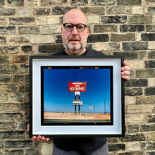 Load image into Gallery viewer, Richard Heeps holding Sundowner Salton Sea California landscape photograph framed in black.
