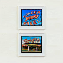 Load image into Gallery viewer, Two framed vintage-style signs on a white wall, one with 'Wonder Wheel' and the other with 'Coca-Cola' artworks by Richard Heeps
