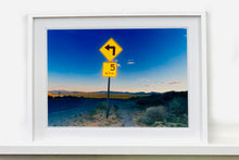 Load image into Gallery viewer, Part of Richard Heeps' 'Dream in Colour' Series, this beautiful picture taken at dusk captures the sunset in the valley.  It was photographed in what was once a goldmine, now a ghost town. The 5MPH sign seems so cautious, but on closer inspection you see that it is peppered with bullet holes, serving as a reminder of its Western past. 