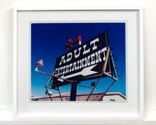 Load image into Gallery viewer, 'Adult Entertainment' photographed in Beatty, Nevada, shows bold typography sitting prominently on an American road sign, against a background of bright blue sky. This fun and cheeky artwork was captured on a road trip through America and features in Richard Heeps' sold out book 'Man's Ruin'. An edition of this artwork recently sold at auction in The Auction Collective exhibition 'Hypercolor-Pop-Culture'.