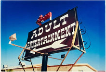 Load image into Gallery viewer, 'Adult Entertainment' photographed in Beatty, Nevada, shows bold typography sitting prominently on an American road sign, against a background of bright blue sky. This fun and cheeky artwork was captured on a road trip through America and features in Richard Heeps' sold out book 'Man's Ruin'. An edition of this artwork recently sold at auction in The Auction Collective exhibition 'Hypercolor-Pop-Culture'.