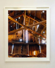 Load image into Gallery viewer, Light breaks through the cracks in the barn on the movie set of Clint Eastwood's Western film 'The Outlaw Josey Wales'. Captured in Kanab, Utah, which was the setting of many Western movies. Photographed by Richard Heeps for his 'Dream in Colour' series.