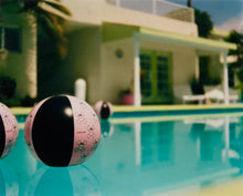 Load image into Gallery viewer, Part of Richard Heeps' 'Dream in Colour' Series, 'Beach Ball' captures Palm Springs mid-century modern architecture behind a trio of pink and black beach balls. The stillness and the subtle colours combine to make a calming artwork with a seductive cinematic vibe.