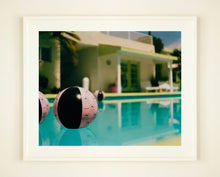 Load image into Gallery viewer, Part of Richard Heeps' 'Dream in Colour' Series, 'Beach Ball' captures Palm Springs mid-century modern architecture behind a trio of pink and black beach balls. The stillness and the subtle colours combine to make a calming artwork with a seductive cinematic vibe.