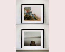 Load image into Gallery viewer, 'Beach Huts', photographed by Richard Heeps in one of his favourite areas of the UK, the port town of Wells-next-the-sea, Norfolk. This piece captures the classic quintessential beach hut on an atmospherically foggy day.