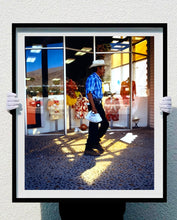 Load image into Gallery viewer, 'Boutique' is street portrait, taken in Palm Springs, California. This piece is different from Richard Heeps' usual style, but everything fell into place: the light, the colours, and the man walking through the shot.