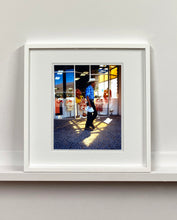 Load image into Gallery viewer, 'Boutique' is street portrait, taken in Palm Springs, California. This piece is different from Richard Heeps' usual style, but everything fell into place: the light, the colours, and the man walking through the shot.