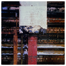 Load image into Gallery viewer, Photograph by Richard Heeps. Warm-toned bricks and metal pipes with a white taped red downpipe at the photo's centre.  Handwriting on the white tape reads Buzzer Was Ear.