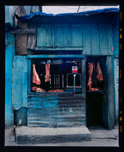 Load image into Gallery viewer, Photograph by Richard Heeps. A butcher's window in the North of India.  A blue painted shack with meat hanging in the window and door.