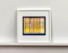 Load image into Gallery viewer, As part of Richard Heeps' series, A Short History of Milan, Delitto A Hollywood features a series of yellow Italian books from a street kiosk. 