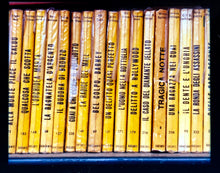 Load image into Gallery viewer, As part of Richard Heeps' series, A Short History of Milan, Delitto A Hollywood features a series of yellow Italian books from a street kiosk. 