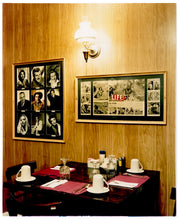 Load image into Gallery viewer, This photograph was taken inside the dining room of the iconic Parry Lodge in Kanab, Utah, which once hosted movie stars of the Western films made in the area. Their faces, cutouts from Life Magazine, adorned the wood panelled walls, which combined with the vintage interior, creates a mid-century cinematic atmosphere. This piece is part of Richard Heeps' 'Dream in Colour' series.
