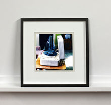Load image into Gallery viewer, Disc Jockey, photographed by Richard Heeps at Preston Hall Museum, he was commissioned to photograph the museum before it went through regeneration. There is an air of nostalgia in the room of this interior photograph, featuring a retro table-top record player with a Decca vinyl record.