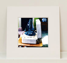Load image into Gallery viewer, Disc Jockey, photographed by Richard Heeps at Preston Hall Museum, he was commissioned to photograph the museum before it went through regeneration. There is an air of nostalgia in the room of this interior photograph, featuring a retro table-top record player with a Decca vinyl record.