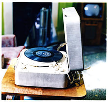 Load image into Gallery viewer, Disc Jockey, photographed by Richard Heeps at Preston Hall Museum, he was commissioned to photograph the museum before it went through regeneration. There is an air of nostalgia in the room of this interior photograph, featuring a retro table-top record player with a Decca vinyl record.