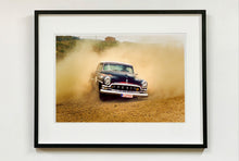 Load image into Gallery viewer, 'Donut' shows a classic American car donut driving on a Norfolk beach in the East of England. This photograph was captured at Hemsby Rock and Roll weekend, and is part of Richard Heeps' Man's Ruin' series.