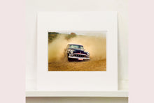 Load image into Gallery viewer, 'Donut' shows a classic American car donut driving on a Norfolk beach in the East of England. This photograph was captured at Hemsby Rock and Roll weekend, and is part of Richard Heeps' Man's Ruin' series.