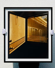 Load image into Gallery viewer, 'Door - Lariat Motel' is a cinematic scene showing a doorway in the glowing evening light, with the setting sun casting shadows across the architecture. Richard Heeps photographed this artwork in Fallon, Nevada whilst on an American road trip. This artwork is part of Richard's 'Dream in Colour' series. 