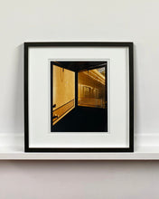 Load image into Gallery viewer, 'Door - Lariat Motel' is a cinematic scene showing a doorway in the glowing evening light, with the setting sun casting shadows across the architecture. Richard Heeps photographed this artwork in Fallon, Nevada whilst on an American road trip. This artwork is part of Richard's 'Dream in Colour' series. 