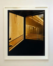 Load image into Gallery viewer, 'Door - Lariat Motel' is a cinematic scene showing a doorway in the glowing evening light, with the setting sun casting shadows across the architecture. Richard Heeps photographed this artwork in Fallon, Nevada whilst on an American road trip. This artwork is part of Richard's 'Dream in Colour' series. 