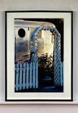 Load image into Gallery viewer, Part of Richard Heeps' 'Dream in Colour' series, this photograph features a white picket fence entrance to the Royal Mansion at the Shady Dell Trailer Park in Bisbee. Arizona. 