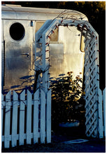 Load image into Gallery viewer, Part of Richard Heeps' 'Dream in Colour' series, this photograph features a white picket fence entrance to the Royal Mansion at the Shady Dell Trailer Park in Bisbee. Arizona. 