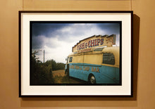 Load image into Gallery viewer, A moody Fenland sky is backdrop to a classic British Fish &amp; Chips Van. The typography and the van itself has a fun fairground feel, contrary to the muted tones of this piece. Part of Richard Heeps series, 'A View of the Fens from the Car with Wings'.