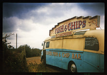 Load image into Gallery viewer, A moody Fenland sky is backdrop to a classic British Fish &amp; Chips Van. The typography and the van itself has a fun fairground feel, contrary to the muted tones of this piece. Part of Richard Heeps series, 'A View of the Fens from the Car with Wings'.