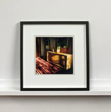 Load image into Gallery viewer, Light streams into the mid-century interior of the Harmony Motel, casting a patterned shadow across the rattan furniture and cactus. This cinematic motel room interior photograph taken in Twentynine Palms, California, is part of Richard Heeps' 'Dream in Colour' series.