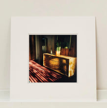Load image into Gallery viewer, Light streams into the mid-century interior of the Harmony Motel, casting a patterned shadow across the rattan furniture and cactus. This cinematic motel room interior photograph taken in Twentynine Palms, California, is part of Richard Heeps' 'Dream in Colour' series.