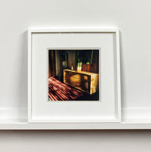 Load image into Gallery viewer, Light streams into the mid-century interior of the Harmony Motel, casting a patterned shadow across the rattan furniture and cactus. This cinematic motel room interior photograph taken in Twentynine Palms, California, is part of Richard Heeps' 'Dream in Colour' series.