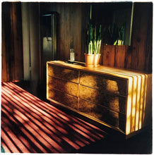 Load image into Gallery viewer, Light streams into the mid-century interior of the Harmony Motel, casting a patterned shadow across the rattan furniture and cactus. This cinematic motel room interior photograph taken in Twentynine Palms, California, is part of Richard Heeps' 'Dream in Colour' series.