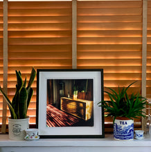 Load image into Gallery viewer, Light streams into the mid-century interior of the Harmony Motel, casting a patterned shadow across the rattan furniture and cactus. This cinematic motel room interior photograph taken in Twentynine Palms, California, is part of Richard Heeps' 'Dream in Colour' series.