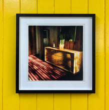 Load image into Gallery viewer, Light streams into the mid-century interior of the Harmony Motel, casting a patterned shadow across the rattan furniture and cactus. This cinematic motel room interior photograph taken in Twentynine Palms, California, is part of Richard Heeps' 'Dream in Colour' series.