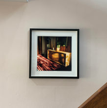 Load image into Gallery viewer, Light streams into the mid-century interior of the Harmony Motel, casting a patterned shadow across the rattan furniture and cactus. This cinematic motel room interior photograph taken in Twentynine Palms, California, is part of Richard Heeps' 'Dream in Colour' series.