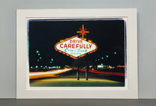 Load image into Gallery viewer, Taken upon leaving Las Vegas, and featured in Richard Heeps' 'Dream in Colour' series, this piece features a classic American neon sign, with the Las Vegas lights disappearing into the distance. 