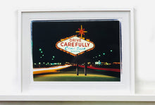 Load image into Gallery viewer, Taken upon leaving Las Vegas, and featured in Richard Heeps' 'Dream in Colour' series, this piece features a classic American neon sign, with the Las Vegas lights disappearing into the distance. 