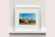 Load image into Gallery viewer, There is a cinematic style to this artwork, 'Lone Pine', taken in a former movie town in California where many Western films were made. Taken outside Richard's iconic interior photograph 'Bonanza Café', set in the Owens Valley against a mountainous  backdrop.