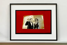 Load image into Gallery viewer, 'Magic Act' is a sepia toned vintage image laid on a bright red backdrop. This photograph was captured at the Red Lodge, a stop often used by performers as they traveled across the country.